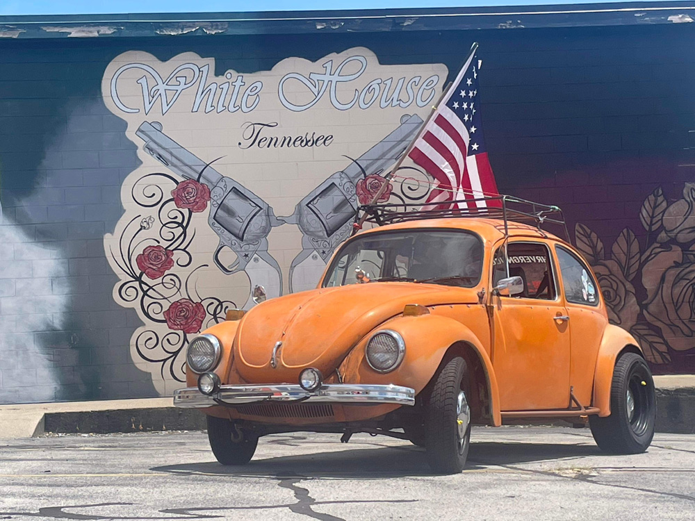 VW Super Beetle parked by a Tennessee mural