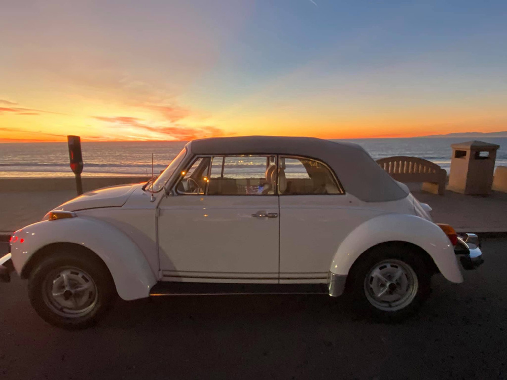 1979 Triple White Beetle parked by the sea