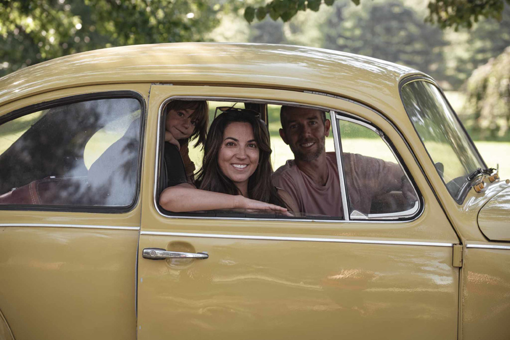 A family sitting in a VW Bug