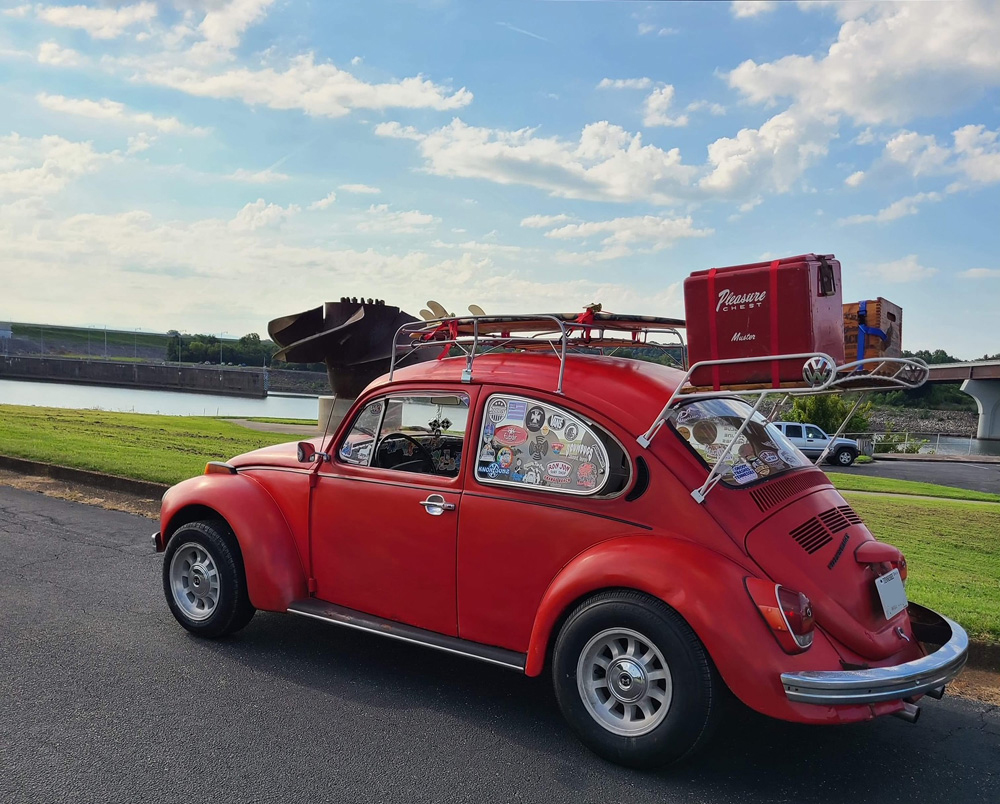 Red VW Bug with a fully loaded roof rack