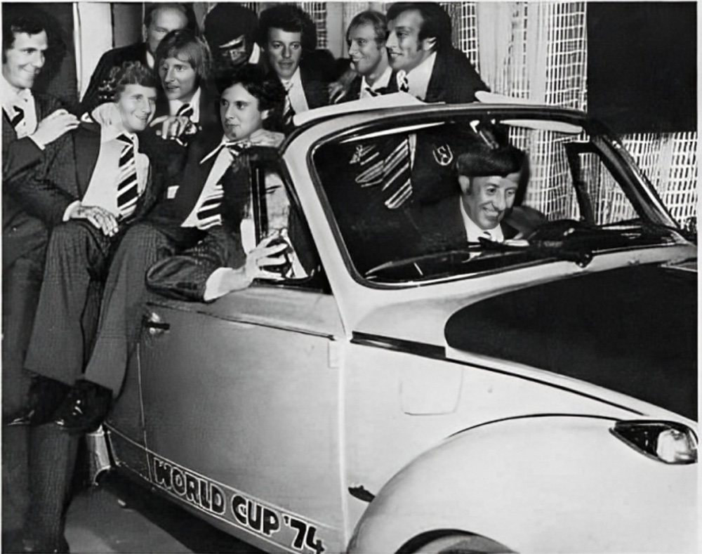 German national team players around a World Cup '74 Super Beetle convertible with coach Helmut Schön at the wheel during the 1974 presentation
